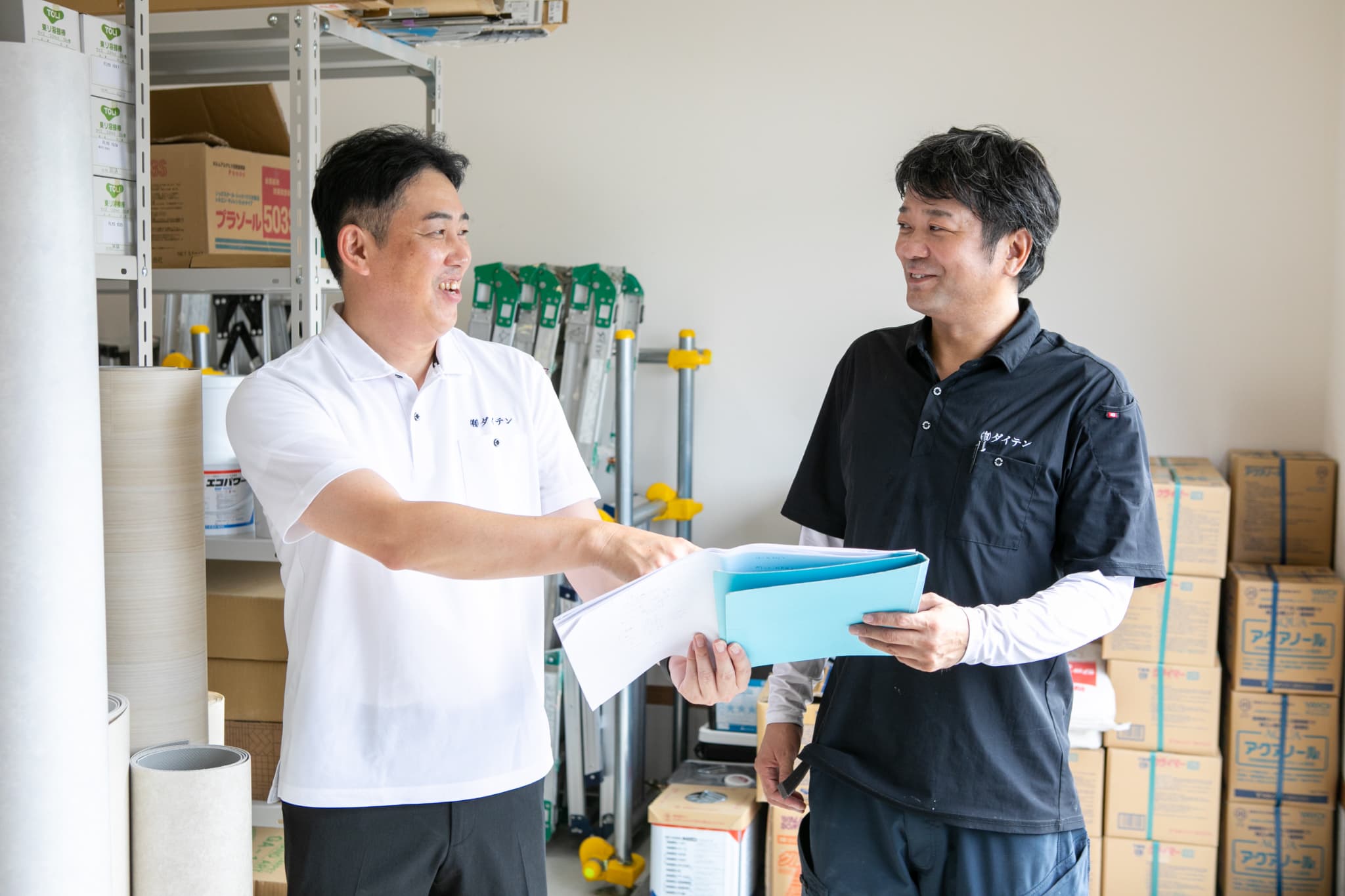 屋根に白の塗装をする作業員の手