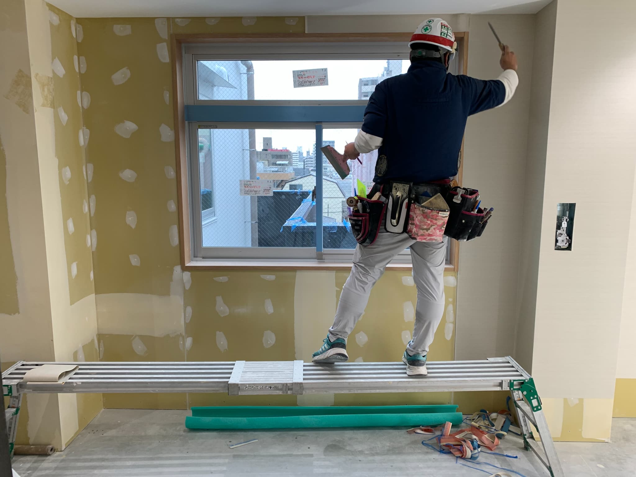 屋根の上から見える町と塗装道具を入れたバケツ